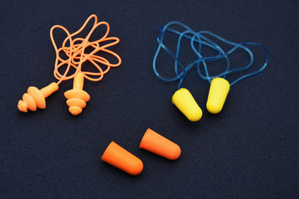 Ear plugs isolated on blue /dark background.Orange and  yellow  ear plugs isolated